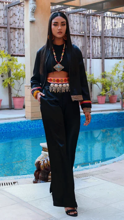 black bomber-style jacket with a black top and relaxed trousers