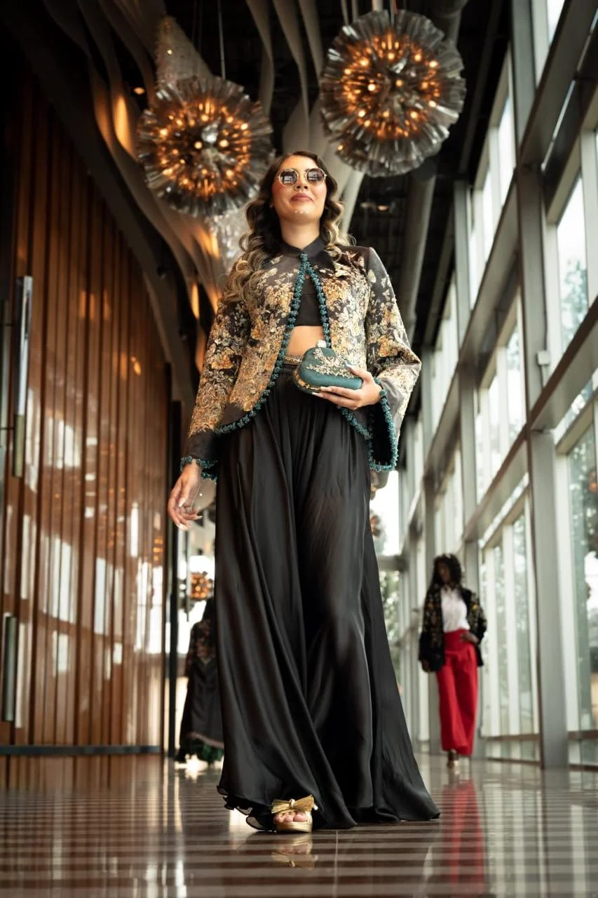 Black and gold embroidered jacket paired with flowing black skirt