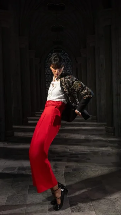Black floral embroidered cropped jacket styled with red wide-leg trousers