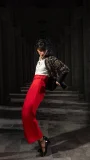 Black floral embroidered cropped jacket styled with red wide-leg trousers