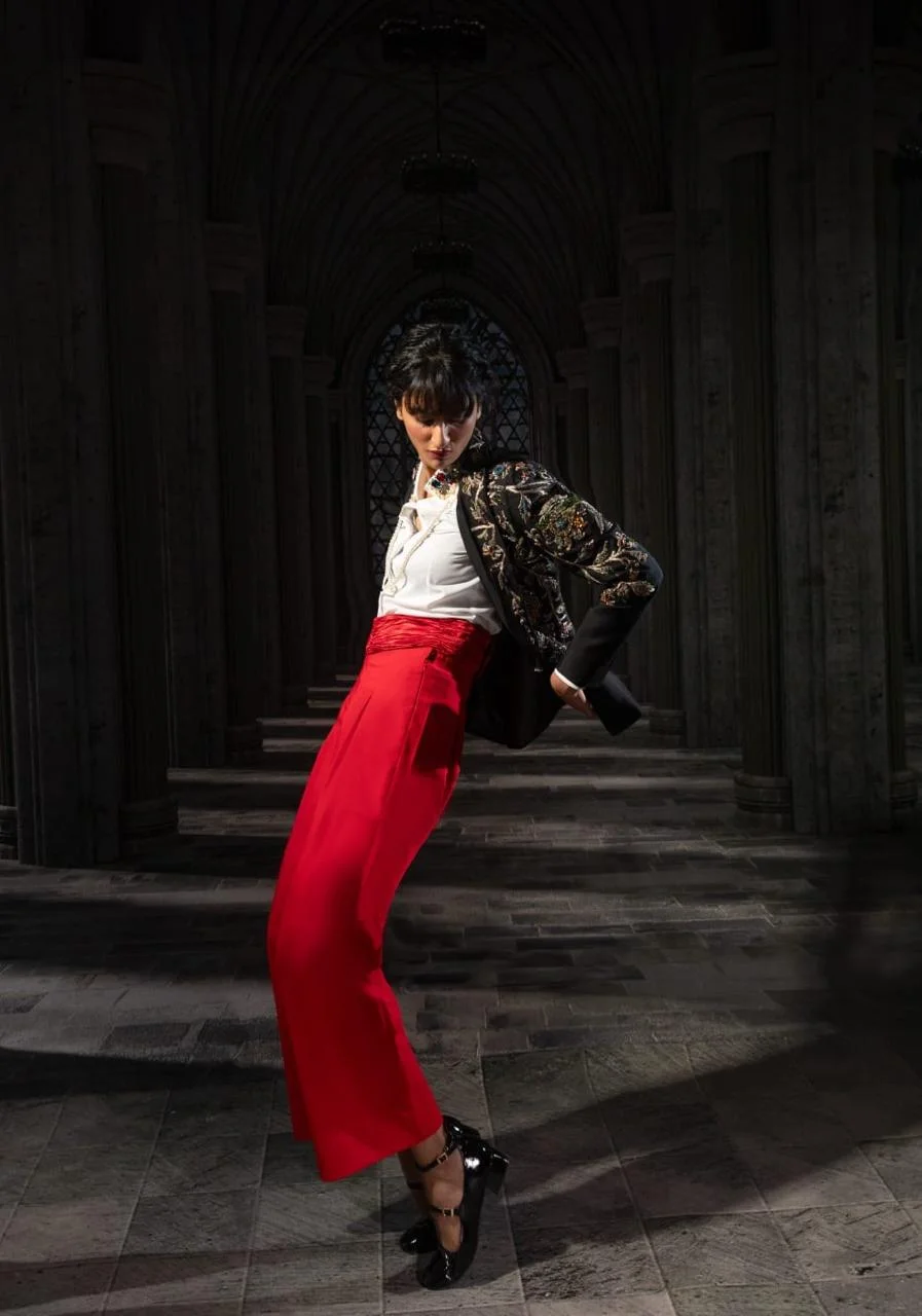 Black floral embroidered cropped jacket styled with red wide-leg trousers