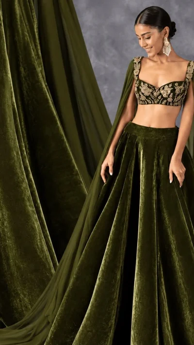 Deep olive-green velvet lehenga with embroidered blouse and cape