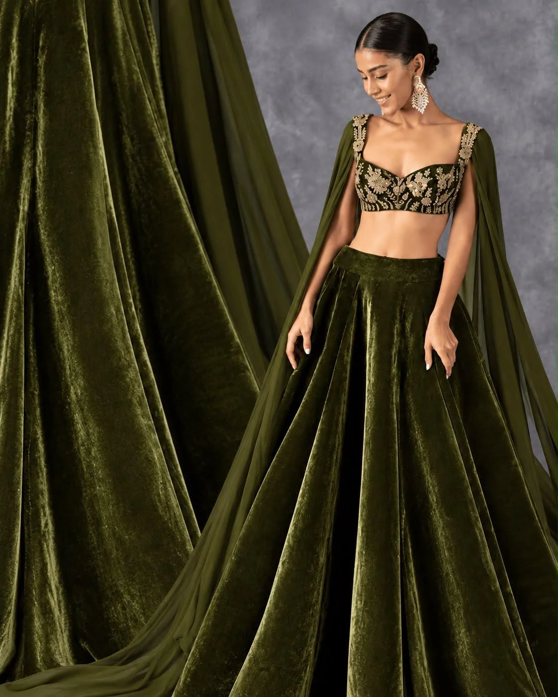 Deep olive-green velvet lehenga with embroidered blouse and cape